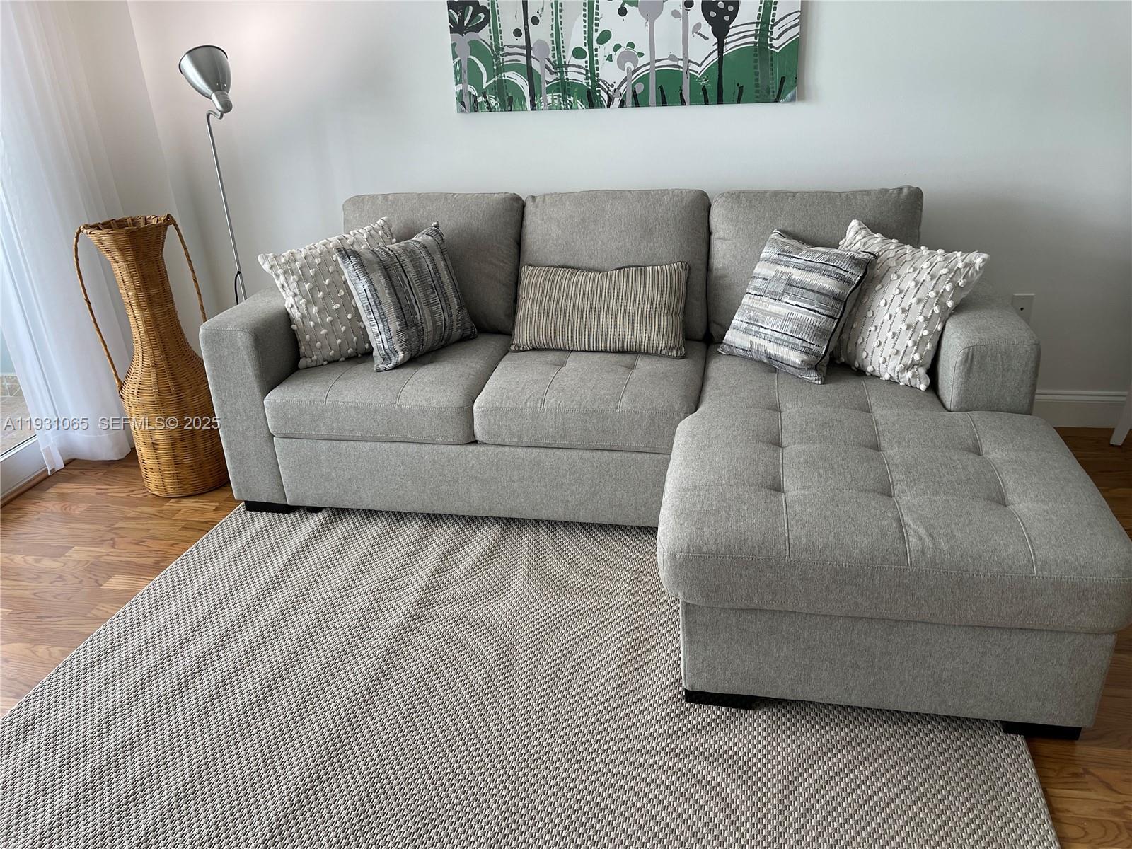 6917 Collins Avenue, Unit 1008 Miami Beach, FL 33141 - Photo 56 of 64 a living room with a couch and a wooden floor