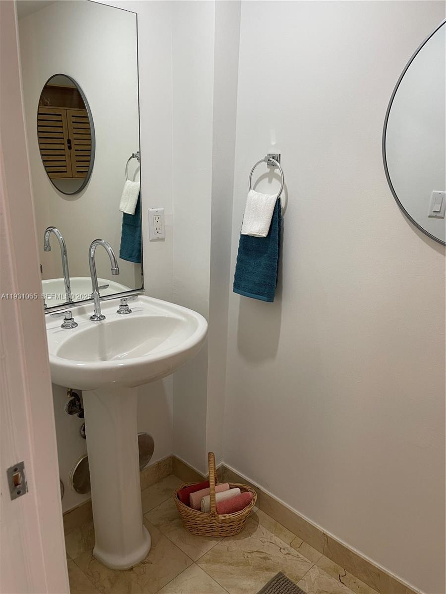6917 Collins Avenue, Unit 1008 Miami Beach, FL 33141 - Photo 7 of 64 a bathroom with a sink and a mirror