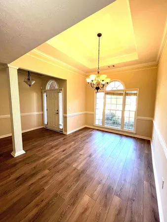 a view of a room with wooden floor staircase and a kitchen