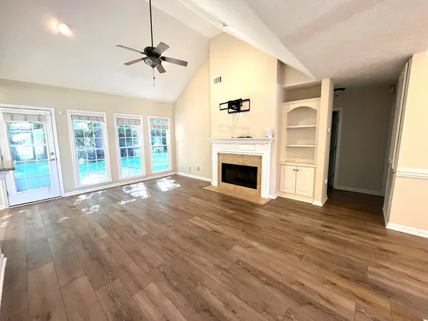 an empty room with windows and fireplace