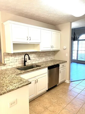 a kitchen with granite countertop a sink stainless steel appliances and cabinets