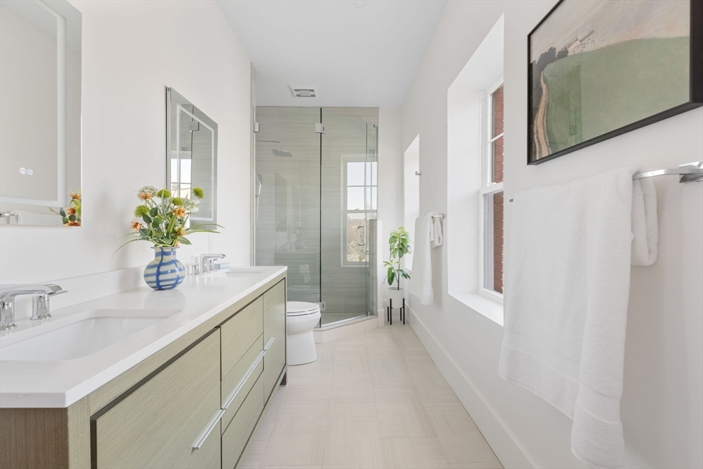 65 Pleasant Street, Unit 3 Brookline, MA 02446 - Photo 12 of 19 a spacious bathroom with a granite countertop sink a mirror and a shower