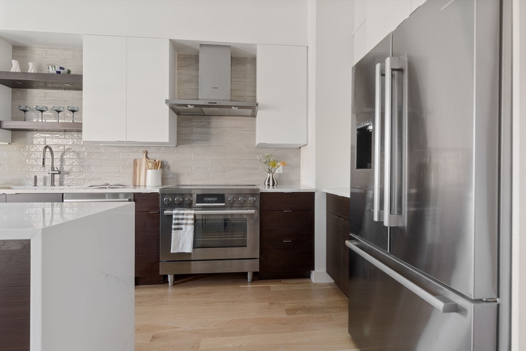 65 Pleasant Street, Unit 3 Brookline, MA 02446 - Photo 5 of 19 a kitchen with stainless steel appliances granite countertop a refrigerator and a sink