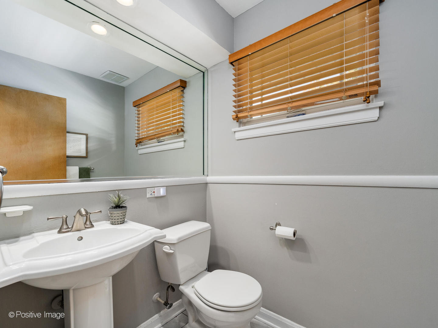 801 Windsor Road Glenview, IL 60025 - Photo 14 of 29 a bathroom with a sink a toilet and a mirror