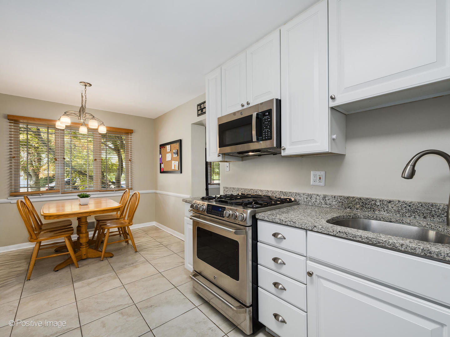 801 Windsor Road Glenview, IL 60025 - Photo 10 of 29 a kitchen with stainless steel appliances granite countertop a stove a sink and a microwave