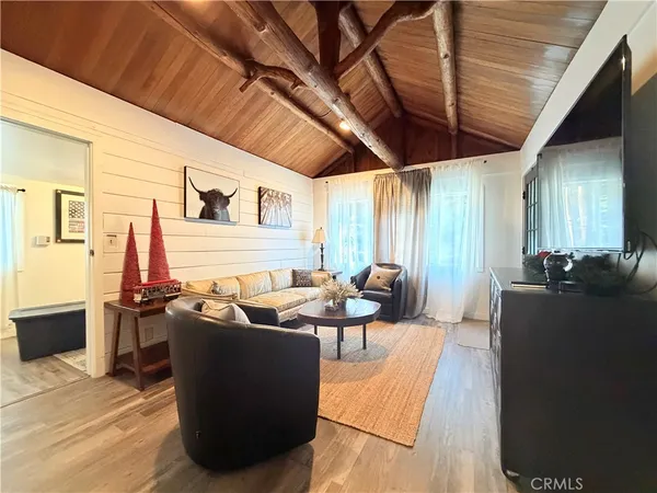 a living room with furniture a flat screen tv and a table