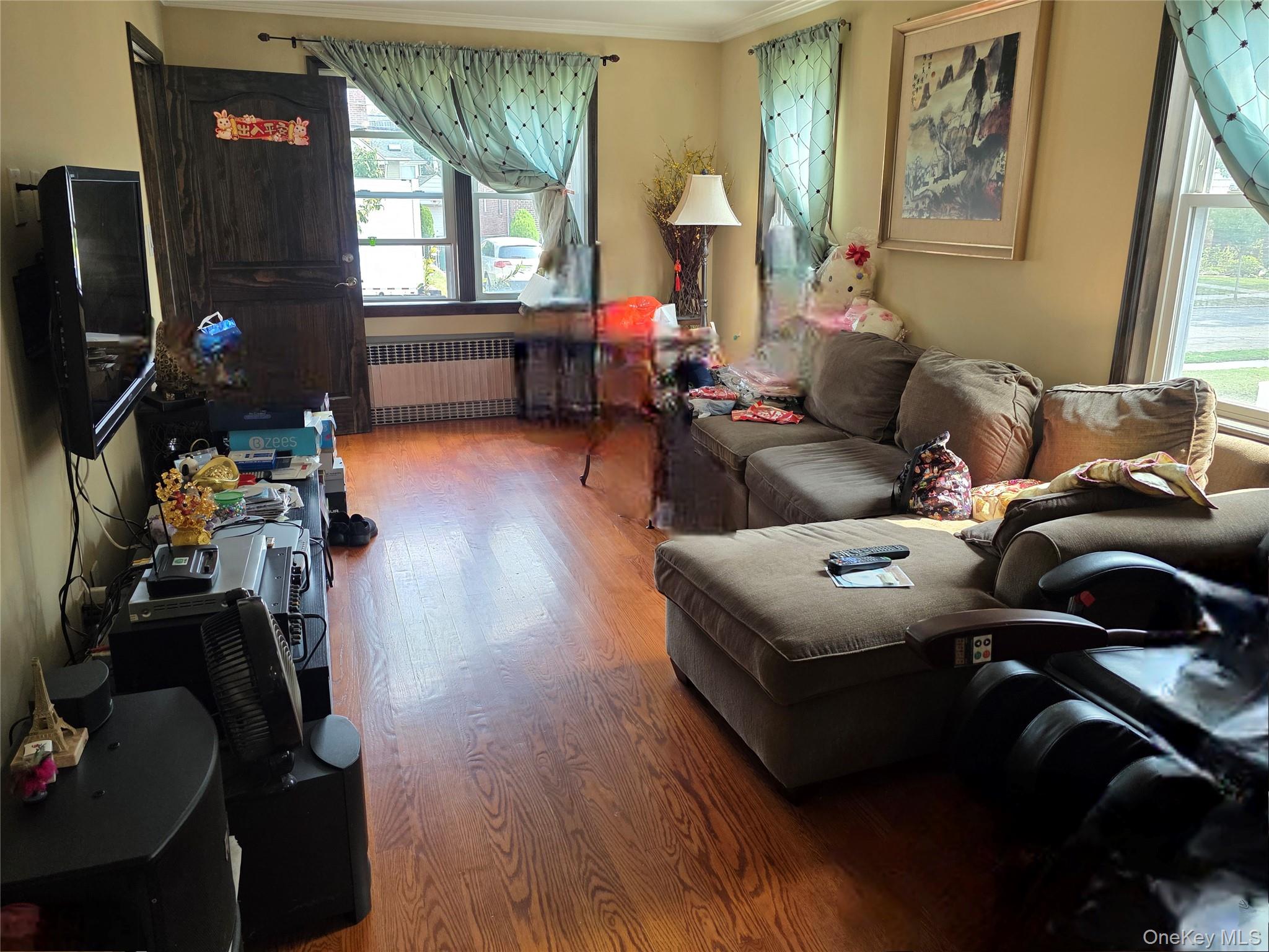 65-26 167th Street Queens, NY 11365 - Photo 4 of 15 Living room with radiator heating unit, light wood-style flooring, and crown molding