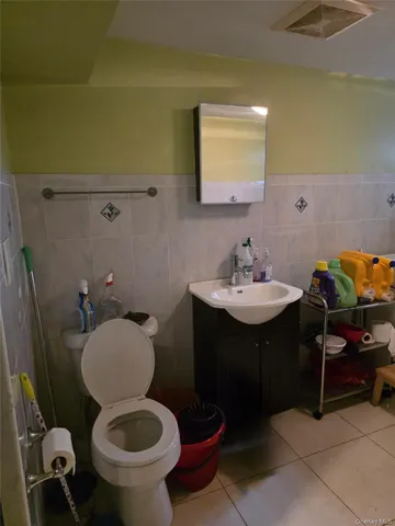 a bathroom with a toilet sink and mirror