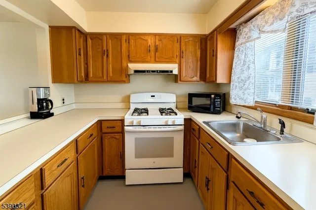 a kitchen with cabinets appliances a sink and a counter top space