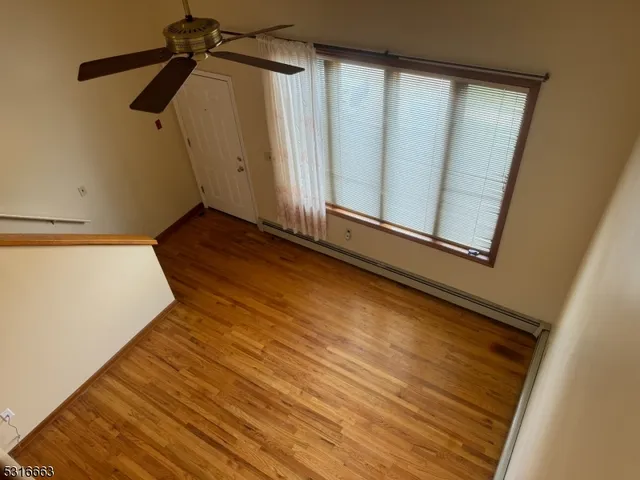 a view of a room with wooden floor and a window