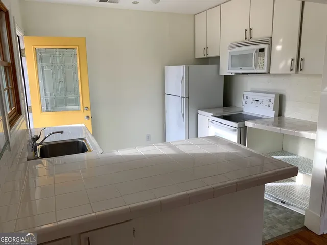 a bedroom with a bed and a refrigerator