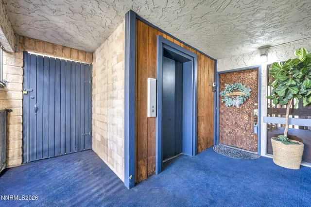 a dining room with furniture a rug a flat screen tv and a large window