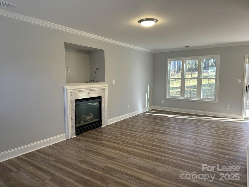 15210 Tracy Beth Road Huntersville, NC 28078 - Photo 6 of 13 an empty room with wooden floor fireplace and windows