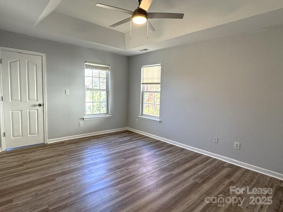 15210 Tracy Beth Road Huntersville, NC 28078 - Photo 8 of 13 an empty room with wooden floor ceiling fan and windows
