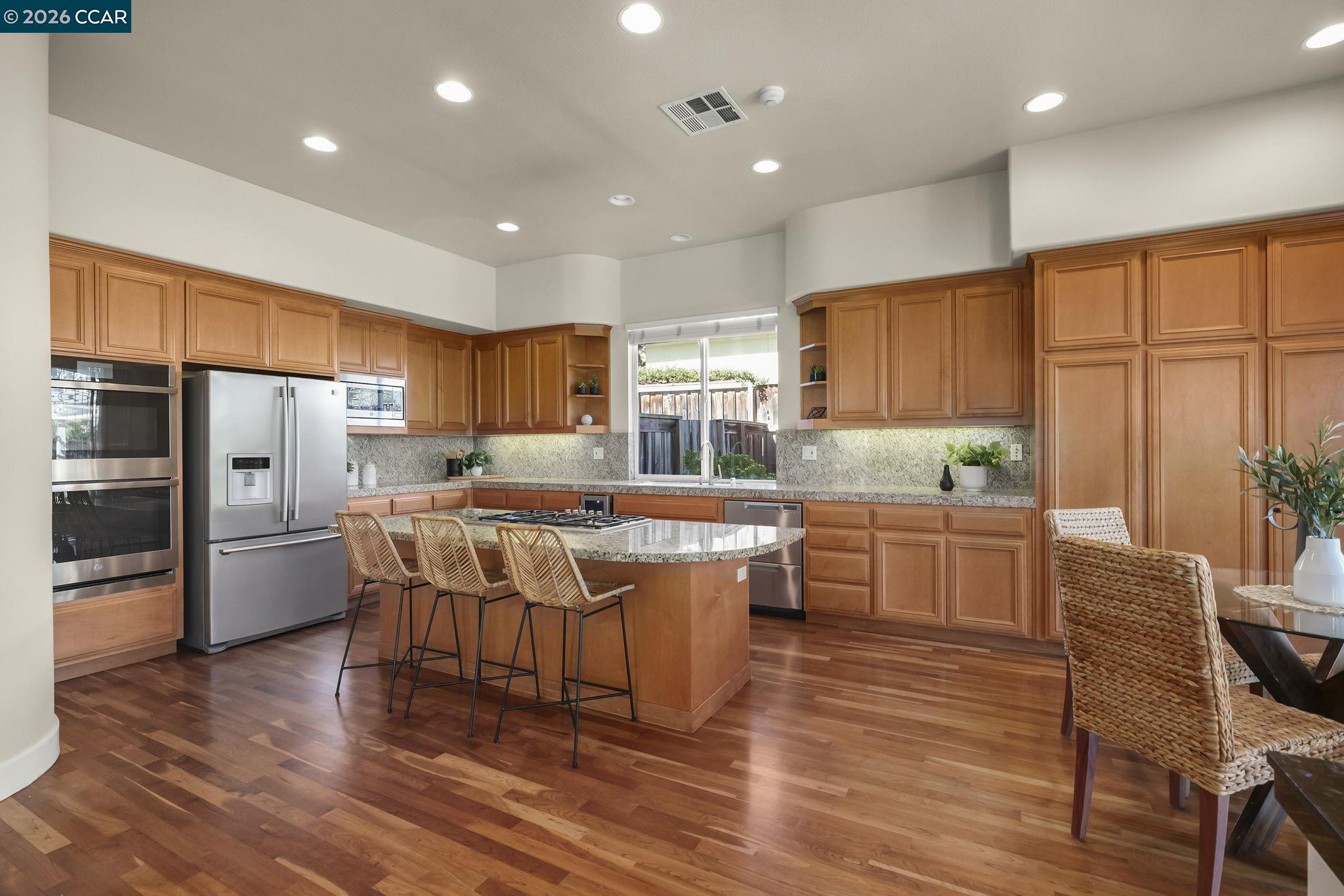 2000 Sorrelwood Court San Ramon, CA 94582 - Photo 9 of 42 a kitchen with stainless steel appliances granite countertop a kitchen island hardwood floor sink stove dining table and chairs