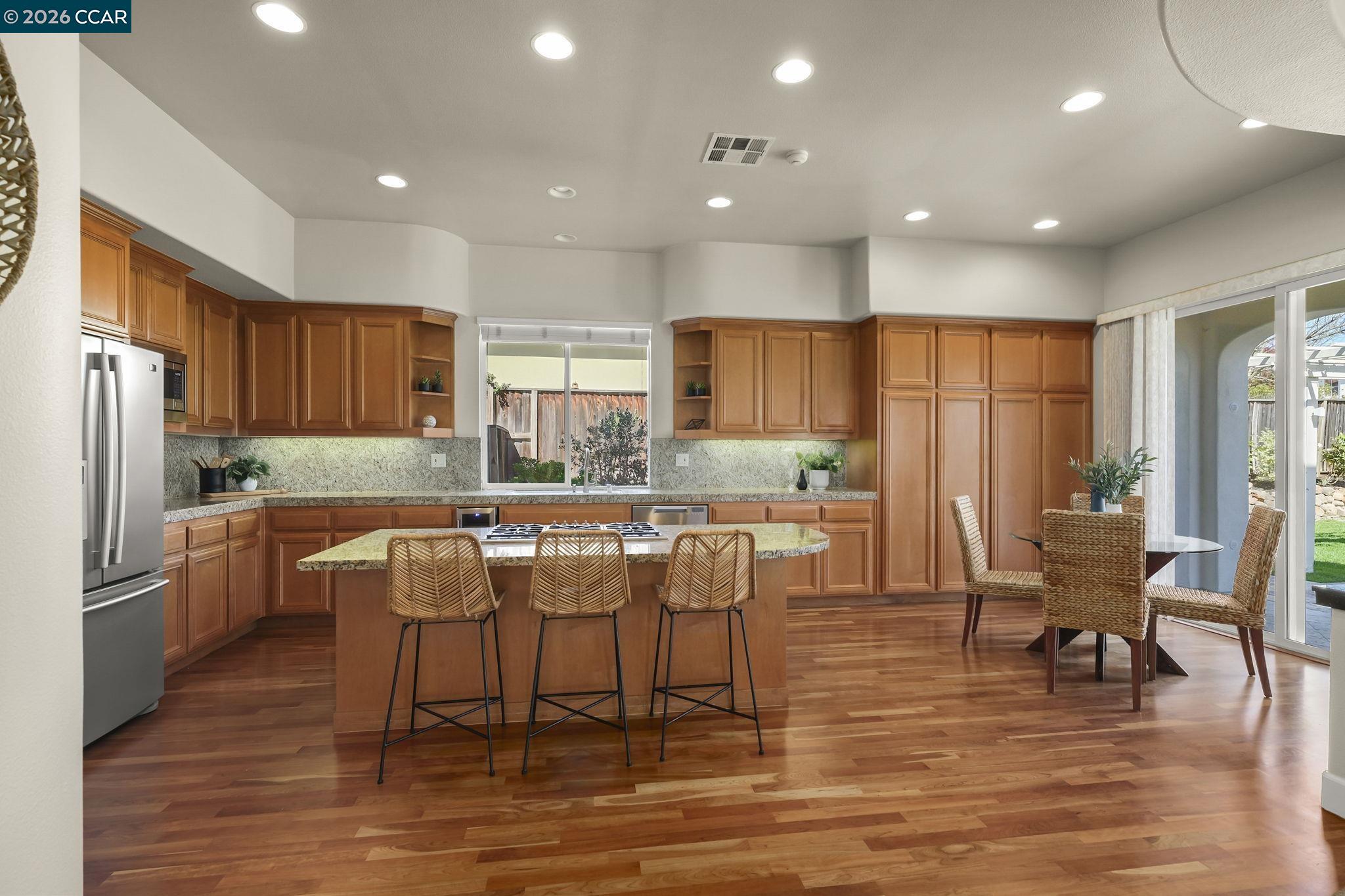 2000 Sorrelwood Court San Ramon, CA 94582 - Photo 10 of 42 a kitchen with stainless steel appliances granite countertop a dining table chairs refrigerator and sink