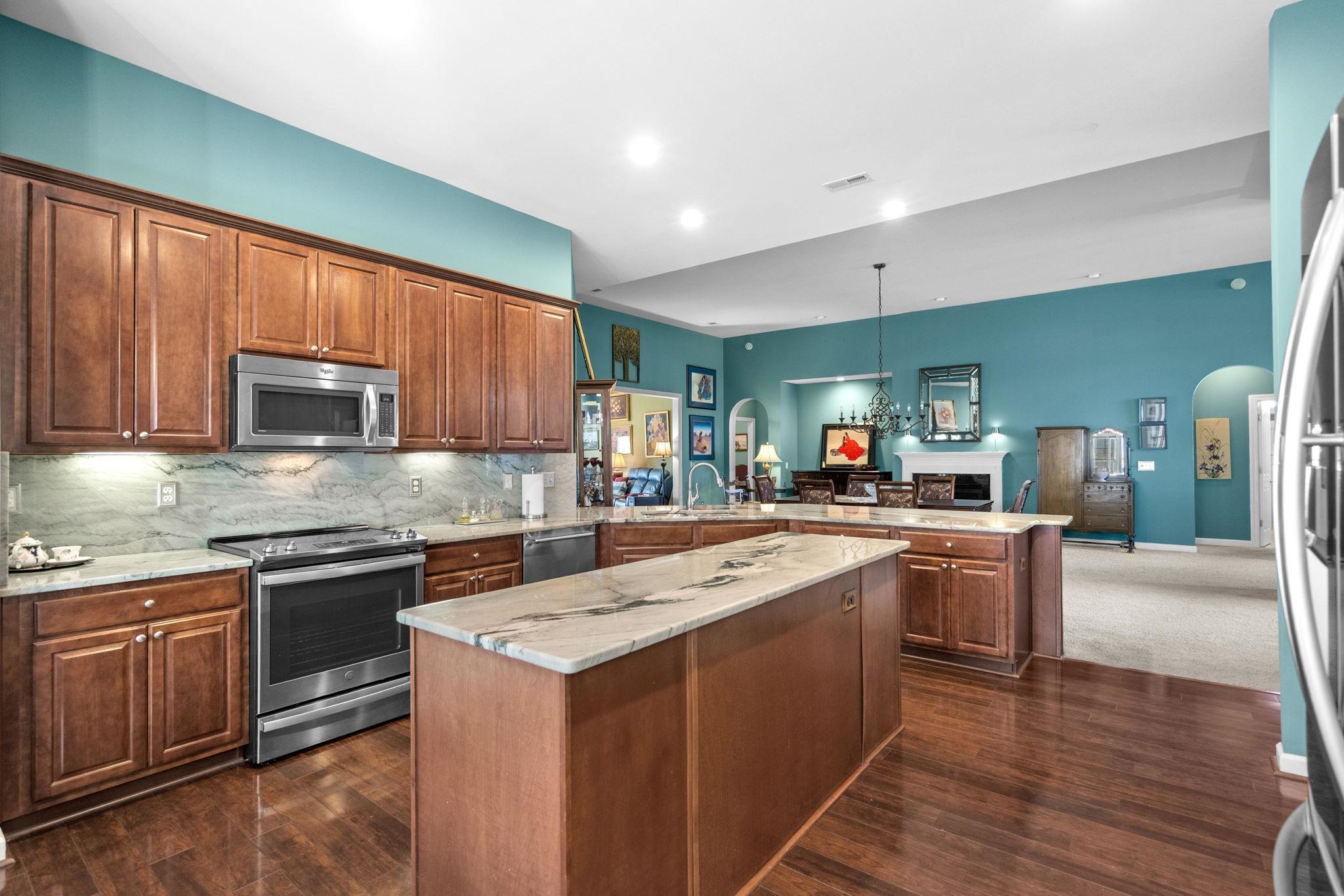 699 Bullrush Court Calabash, NC 28467 - Photo 12 of 40 Kitchen featuring arched walkways, stainless steel appliances, light stone counters, a peninsula, and backsplash