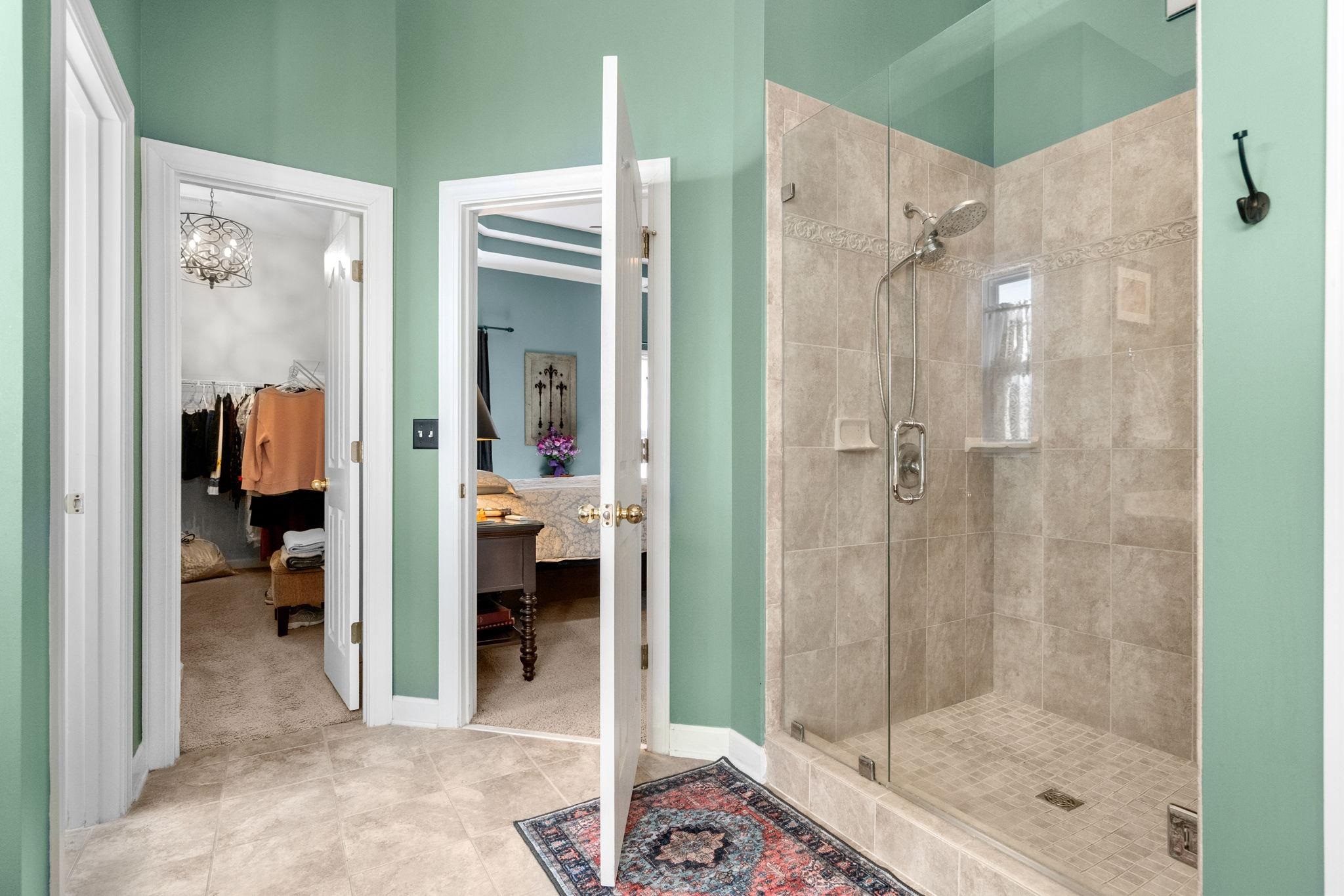 699 Bullrush Court Calabash, NC 28467 - Photo 17 of 40 Ensuite bathroom with a shower stall, a chandelier, tile patterned floors, and a spacious closet
