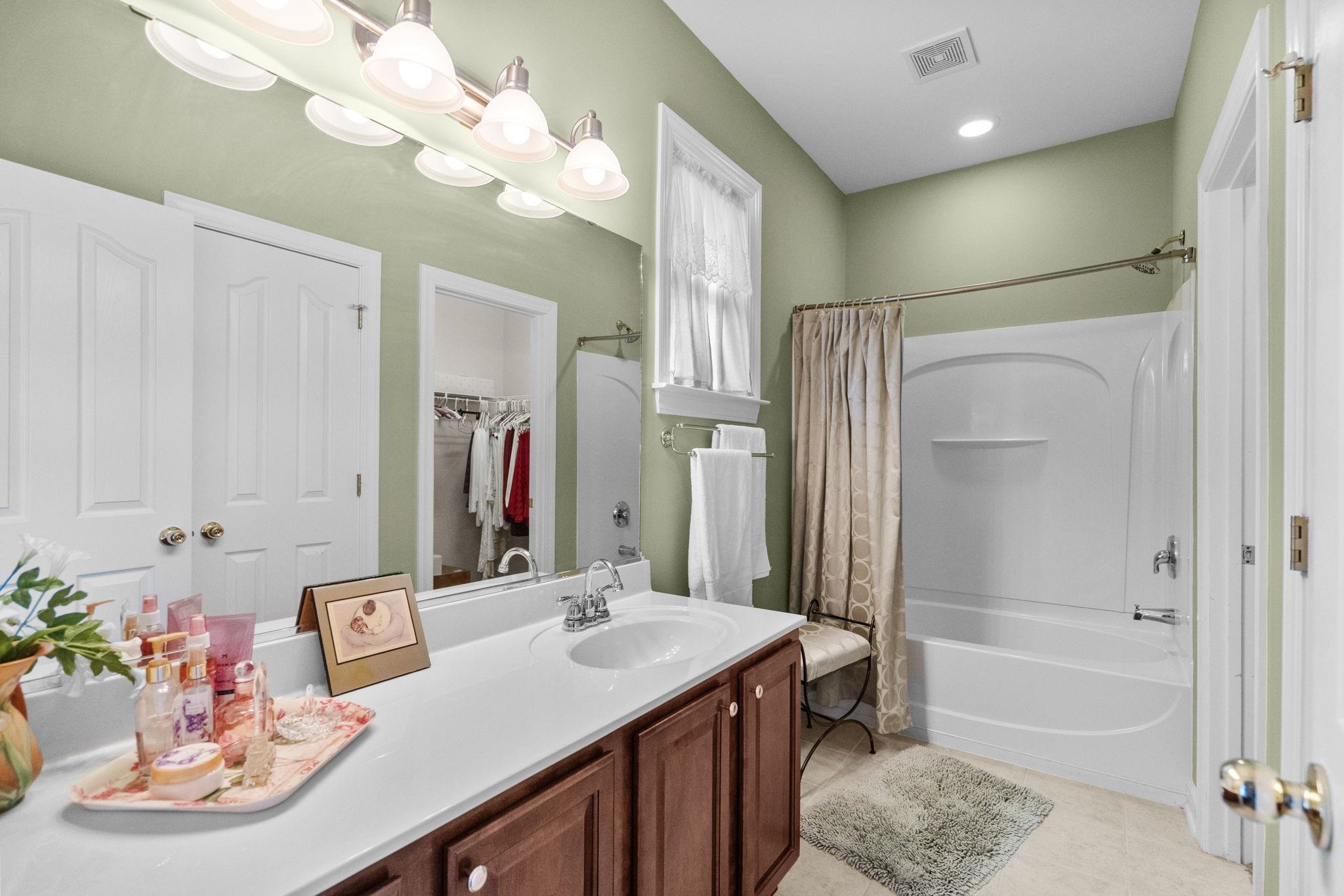 699 Bullrush Court Calabash, NC 28467 - Photo 22 of 40 Full bathroom featuring vanity, shower / tub combo, a spacious closet, and light tile patterned floors