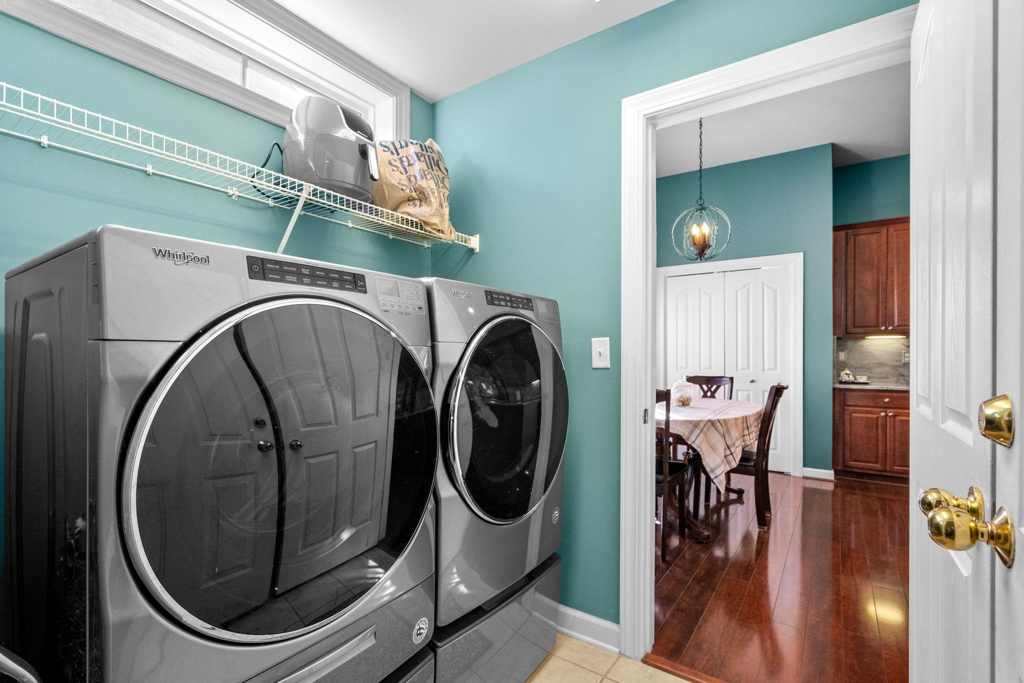 699 Bullrush Court Calabash, NC 28467 - Photo 27 of 40 Laundry area featuring washer and clothes dryer, wood finished floors, and a chandelier