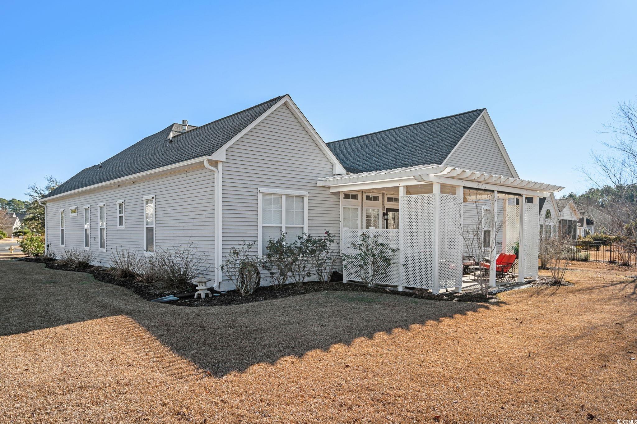 699 Bullrush Court Calabash, NC 28467 - Photo 33 of 40 View of property exterior featuring roof with shingles and a yard