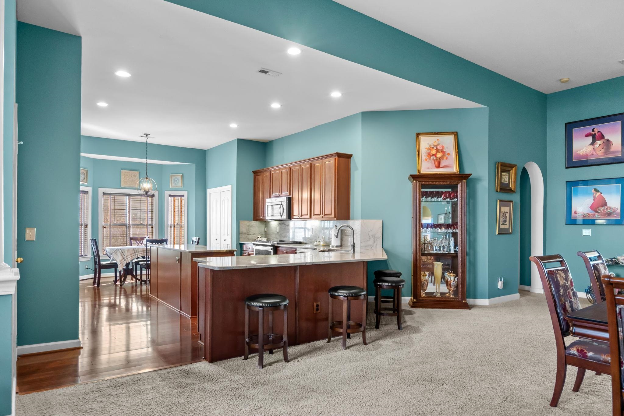 699 Bullrush Court Calabash, NC 28467 - Photo 8 of 40 Kitchen with a breakfast bar area, decorative light fixtures, a peninsula, dark carpet, and tasteful backsplash
