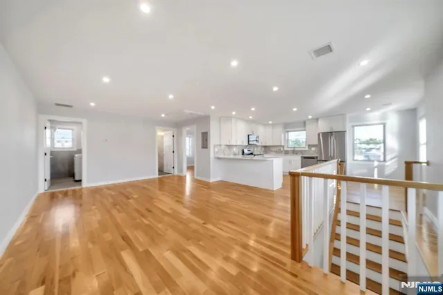 a view of kitchen with kitchen island granite countertop a sink and a stove top oven