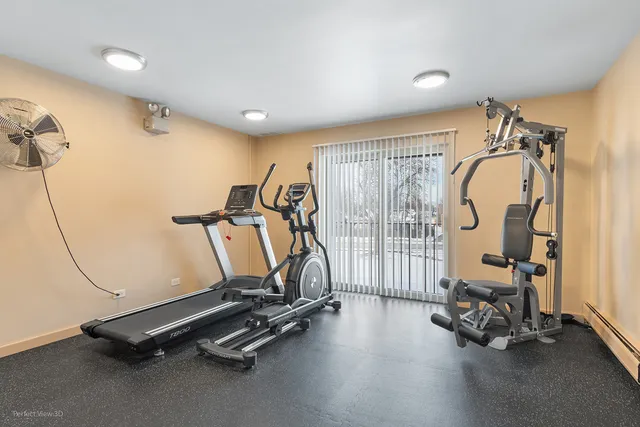 a brick house with a small yard plants and large tree
