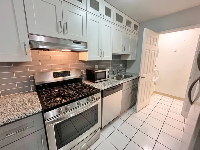 a kitchen with stainless steel appliances granite countertop a stove a sink and a refrigerator