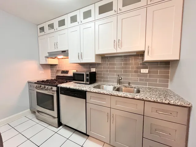 a kitchen with stainless steel appliances granite countertop white cabinets a sink and dishwasher