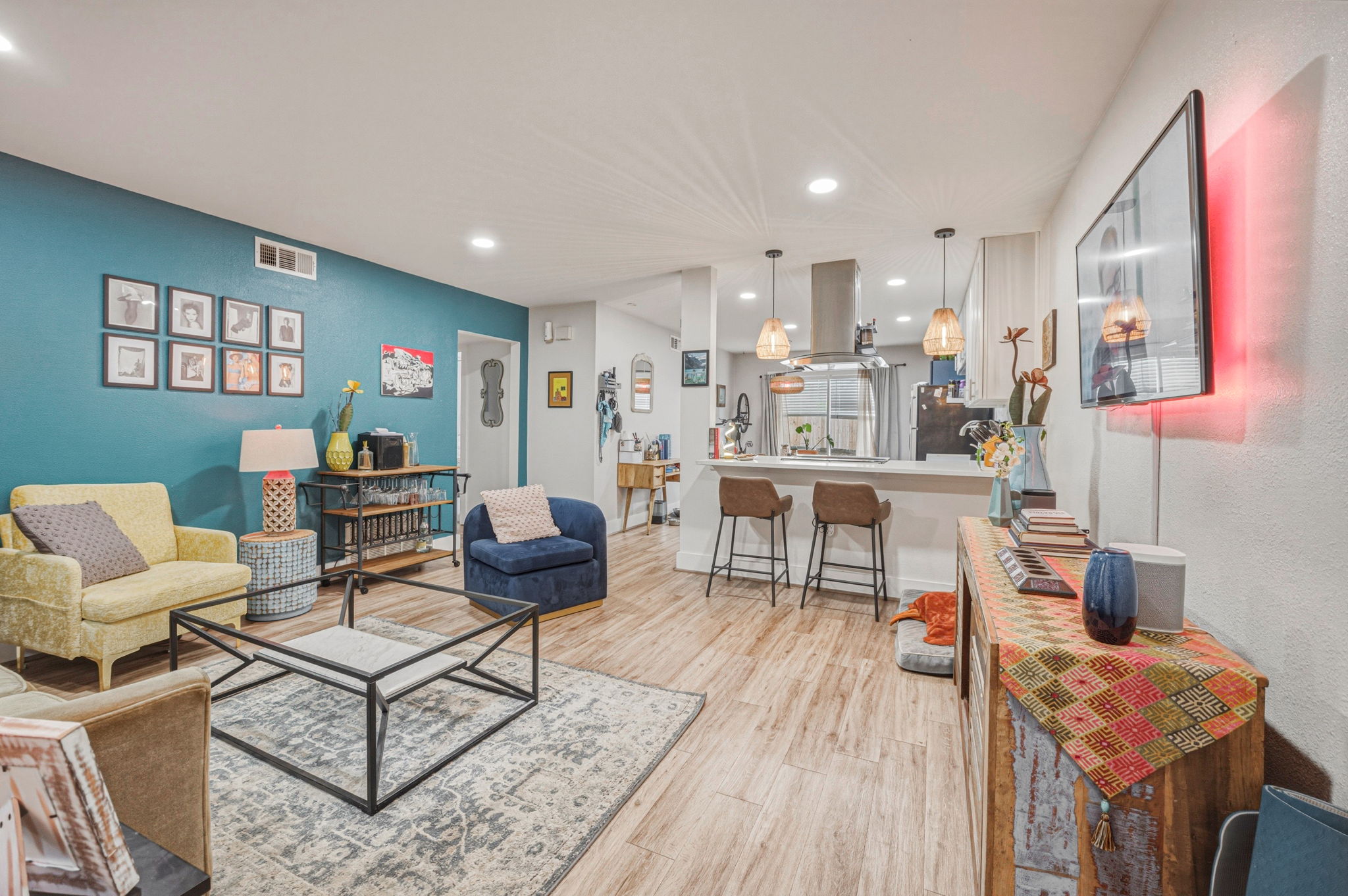 5332 Balcones Drive, Unit B Austin, TX 78731 - Photo 1 of 15 Open concept living area featuring light-toned flooring, recessed lighting, and a kitchen island with pendant lighting