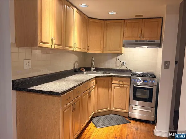 a kitchen with stainless steel appliances granite countertop a sink a stove and a microwave