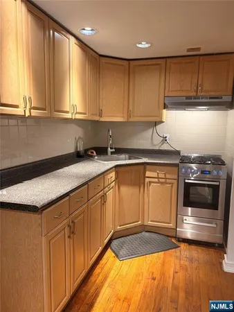 a kitchen with granite countertop a sink a stove a microwave and cabinets