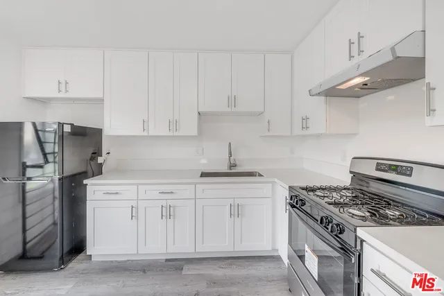 a kitchen with cabinets appliances and a counter space