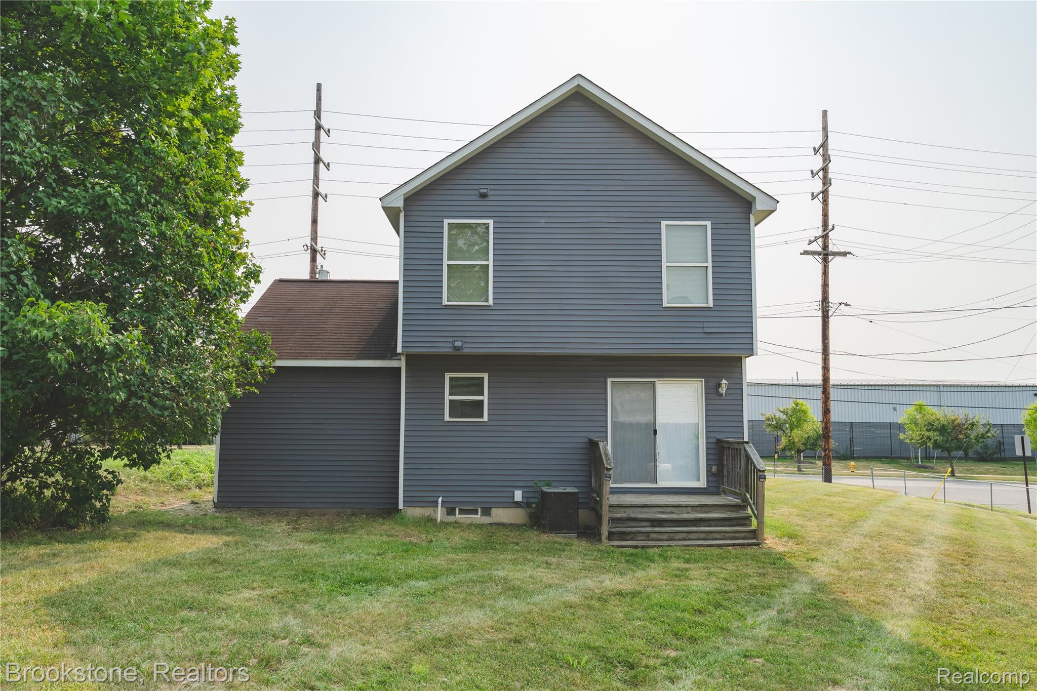 270 Franklin Road Pontiac, MI 48341 - Photo 40 of 46 Rear exterior featuring gray horizontal siding, a brown shingle roof, and a sliding glass door with a wood-finish deck