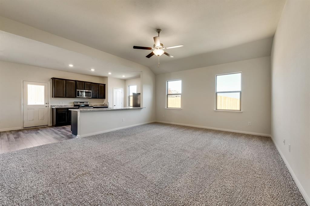 9813 Dan Meyer Drive Fort Worth, TX 76140 - Photo 3 of 8 a view of a kitchen with a stove cabinets a ceiling fan and wooden floor