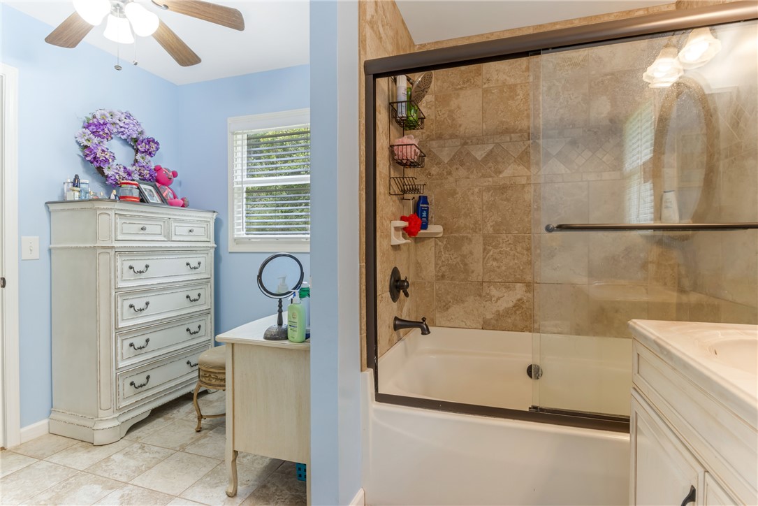 404 Davis Road Liberty, SC 29657 - Photo 27 of 39 A well-lit primary bathroom features a combination tub and shower with tile surround.
