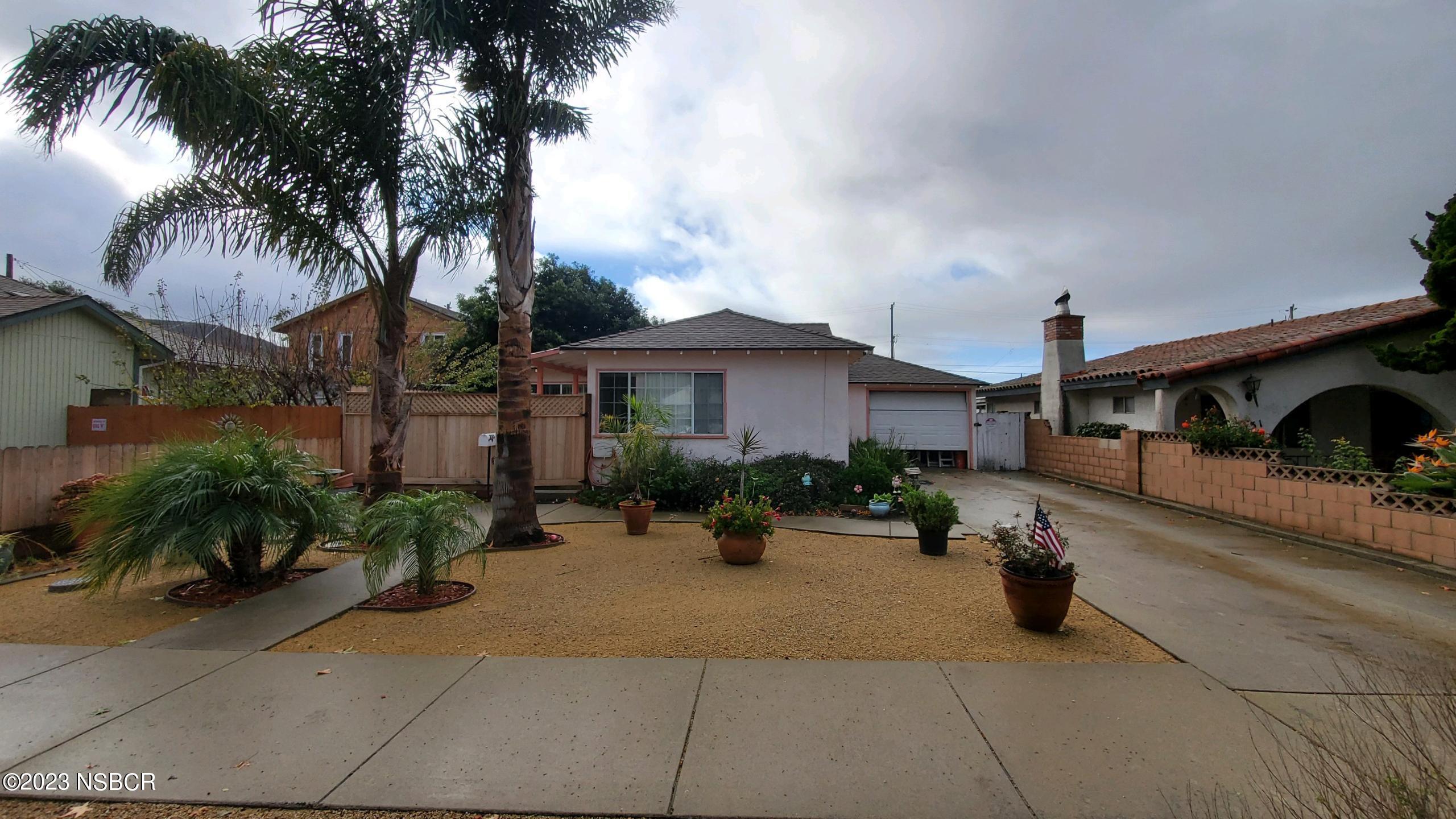 a palm tree sitting in front of a house with a patio
