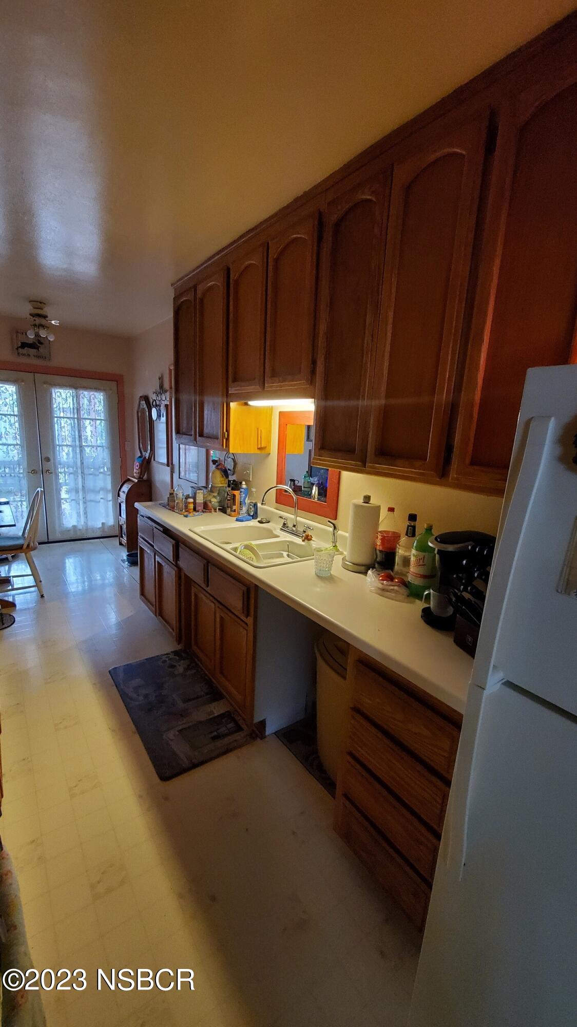 233 South E Street Lompoc, CA 93436 - Photo 7 of 17 a kitchen with stainless steel appliances a stove a sink dishwasher and cabinets with wooden floor