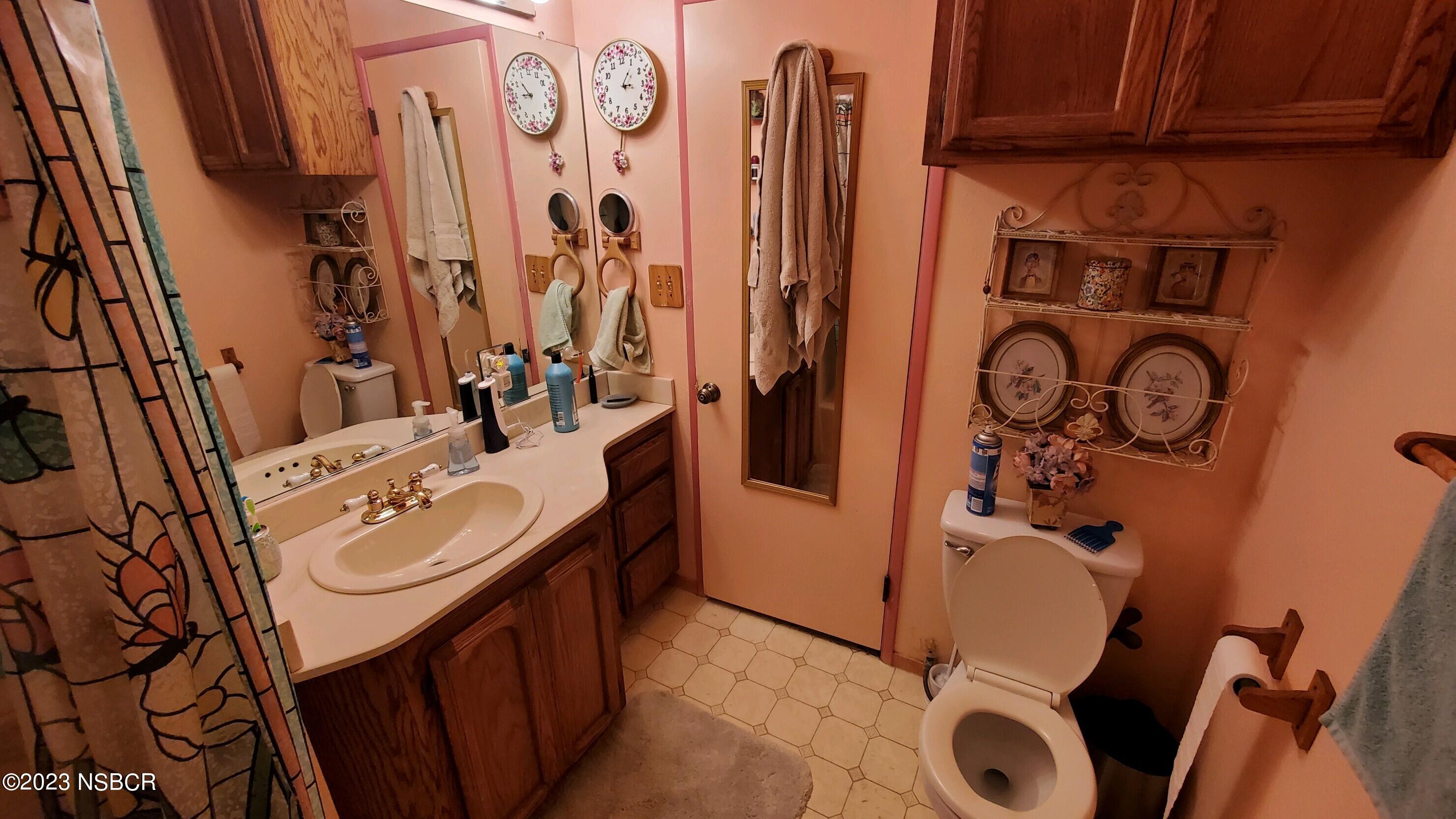 233 South E Street Lompoc, CA 93436 - Photo 10 of 17 a bathroom with a sink and mirror