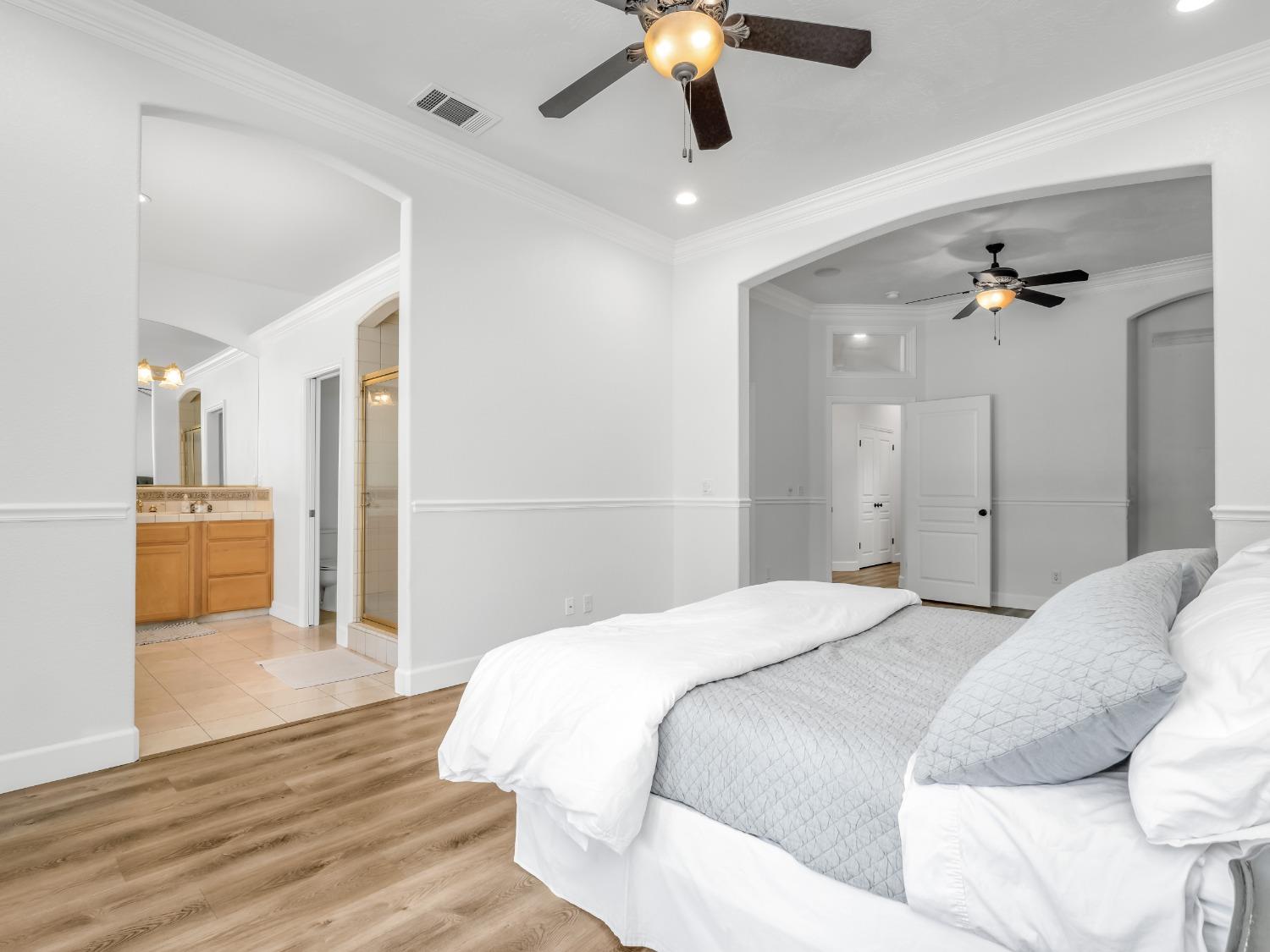 371 West Warwick Avenue Clovis, CA 93619 - Photo 21 of 42 a spacious bedroom with a bed and a chandelier