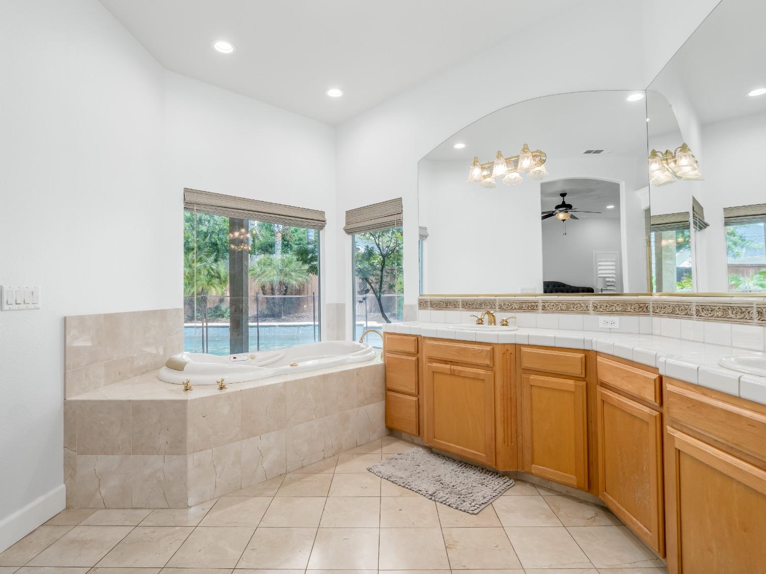 371 West Warwick Avenue Clovis, CA 93619 - Photo 24 of 42 a spacious bathroom with a granite countertop tub sink and mirror