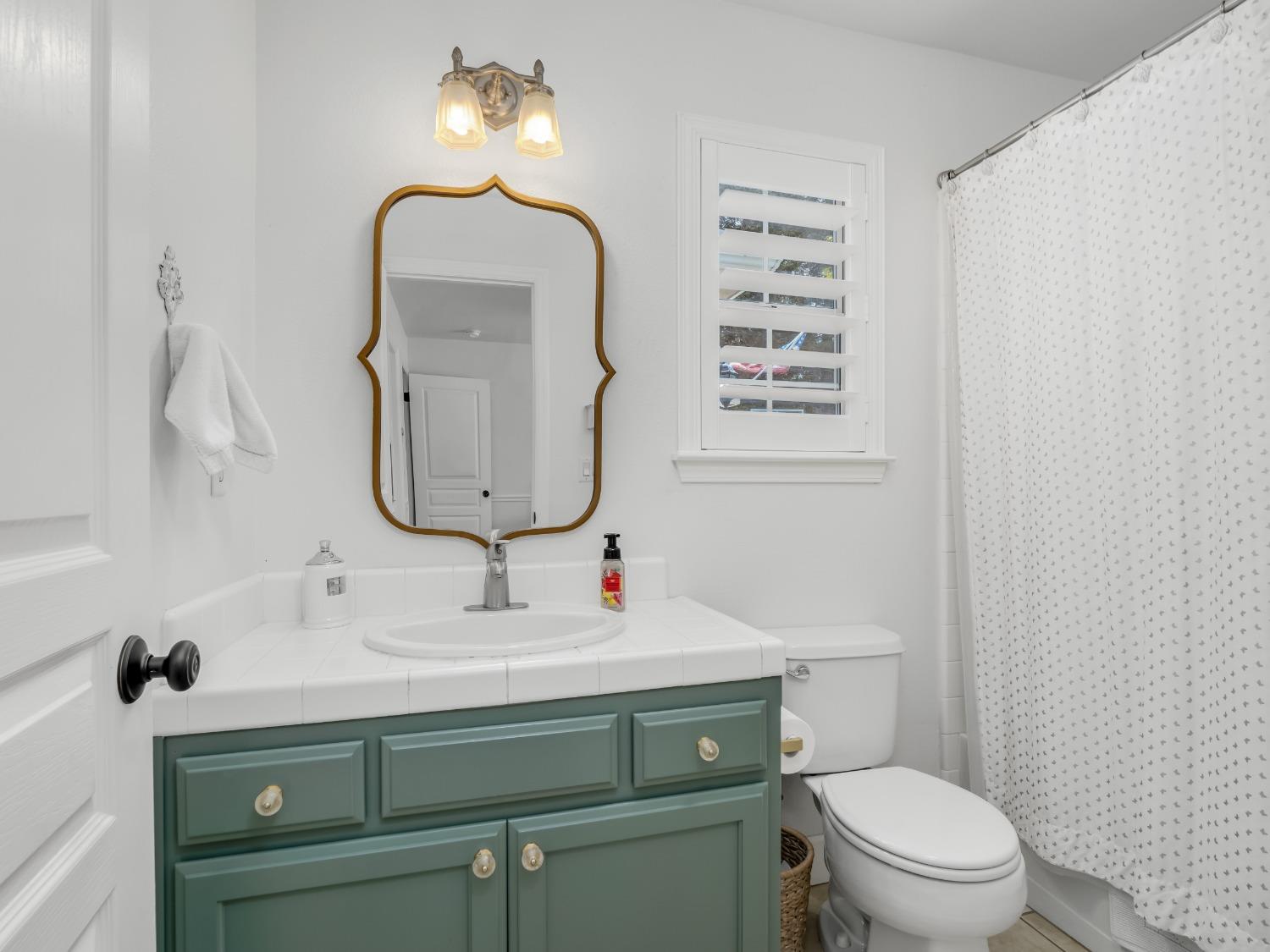 371 West Warwick Avenue Clovis, CA 93619 - Photo 32 of 42 a bathroom with a sink toilet and mirror