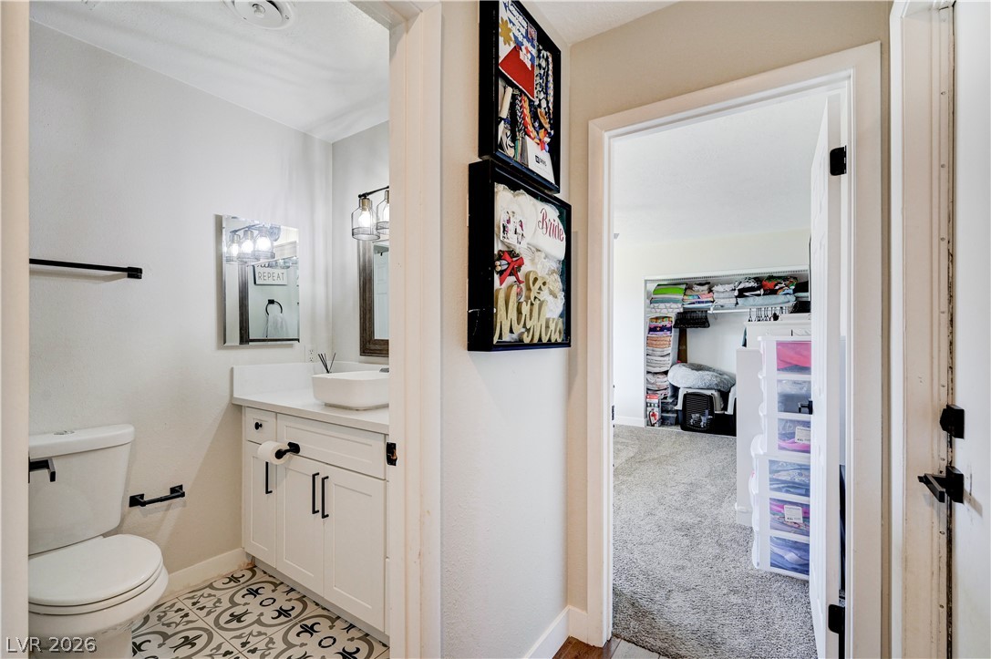 1331 Pinto Road Boulder City, NV 89005 - Photo 24 of 46 Crisp white cabinetry and a modern vessel sink complete this bathroom with patterned tile flooring.