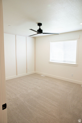 2218 South 635 West, Unit A Perry, UT 84302 - Photo 6 of 18 Plush carpeting, paneling accents, modern ceiling fan, and window with blinds