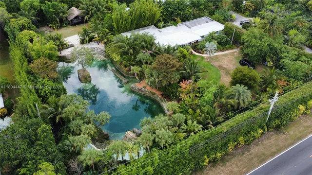 an aerial view of a house with a yard and large trees