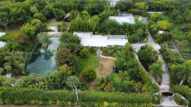 an aerial view of a house with a yard and lake view