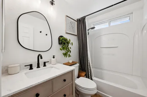 a bathroom with a sink a mirror a toilet and a shower