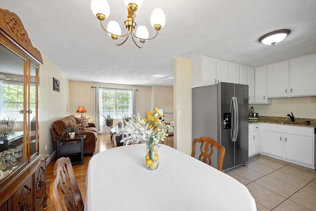 85 Tower Street Hudson, MA 01749 - Photo 7 of 25 a kitchen with stainless steel appliances granite countertop a refrigerator a microwave oven a sink dining table and chairs