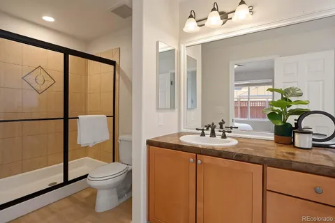 a bathroom with a granite countertop sink a toilet and shower